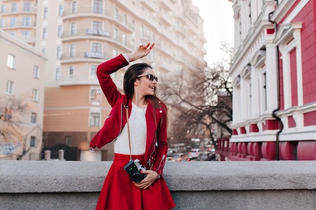 Garota feliz dançando na rua após a sessão de fotos