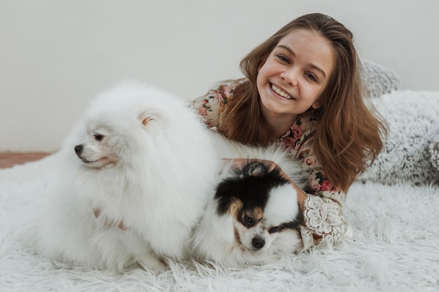 Foto grátis garota feliz de vista frontal e dois cachorros fofinhos