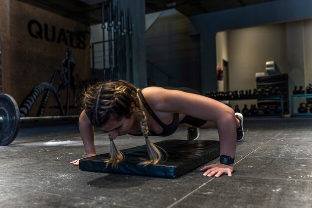 Garota fitness fazendo exercício flexionando