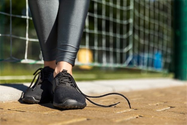 Garota fitness fica em uma pista com atacadores soltos