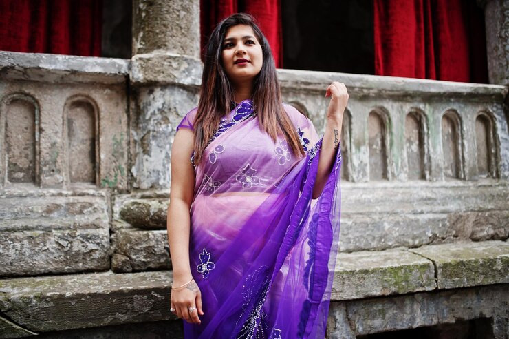 Foto grátis garota hindu indiana no tradicional saree violeta posou na rua contra a velha casa com cortinas vermelhas