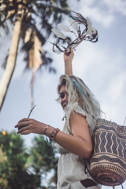 Garota hippie com longos cabelos loiros em um vestido no telhado.