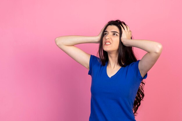 Garota irritada, segurando as mãos na cabeça Foto de alta qualidade