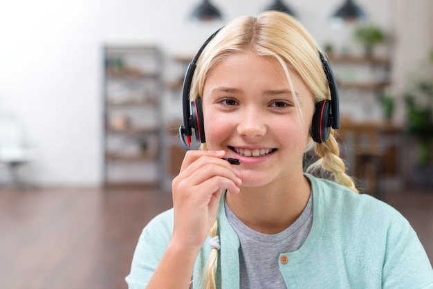 Garota jovem aluno falando em fones de ouvido