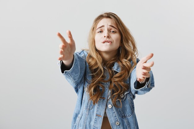 Garota loira tentadora estendendo as mãos com desejo, querendo segurar ou pegar algo