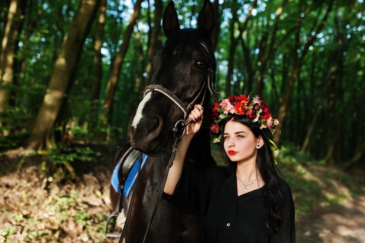 Foto grátis garota mística em grinalda veste de preto com cavalo em madeira