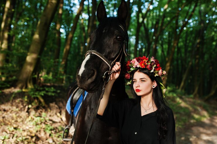 Foto grátis garota mística em grinalda veste de preto com cavalo em madeira