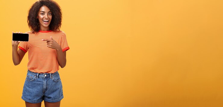 Foto grátis garota mostrando foto no telefone se gabando de suas férias legais, charmosas, amigáveis e sociáveis na áfrica