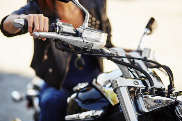 Garota motociclista em uma jaqueta de couro em uma motocicleta