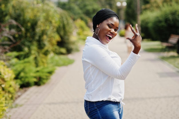 Garota muçulmana africana em moletom branco hijab preto e jeans posou ao ar livre