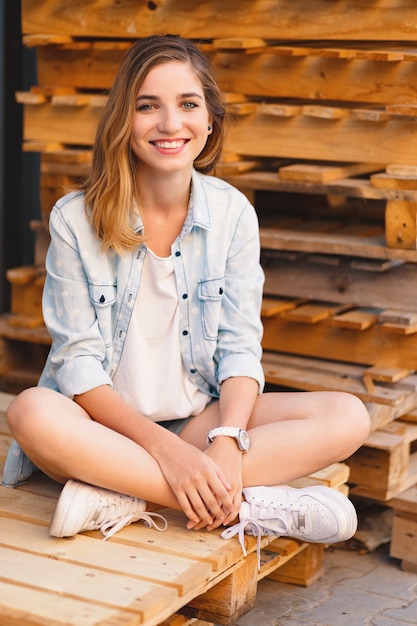 Garota muito sorridente, vestindo jeans, shorts e camisa posando