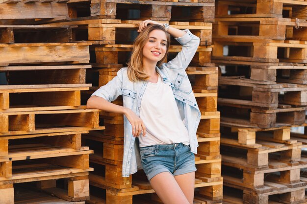 Garota muito sorridente, vestindo jeans, shorts e camisa posando