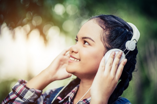 Foto grátis garota ouvindo música com seus fones de ouvido na floresta