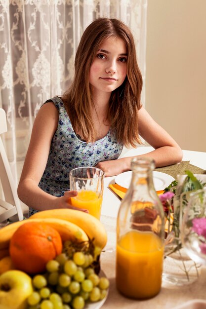 Garota posando na mesa de jantar