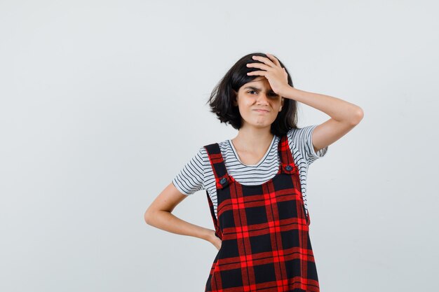 Garota pré-adolescente segurando a mão na cabeça com a camiseta