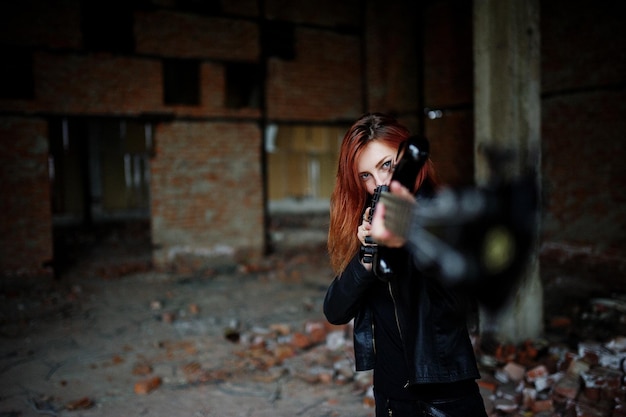 Garota punk de cabelo vermelho veste preto com guitarra baixo em lugar abandonado retrato de músico gótico