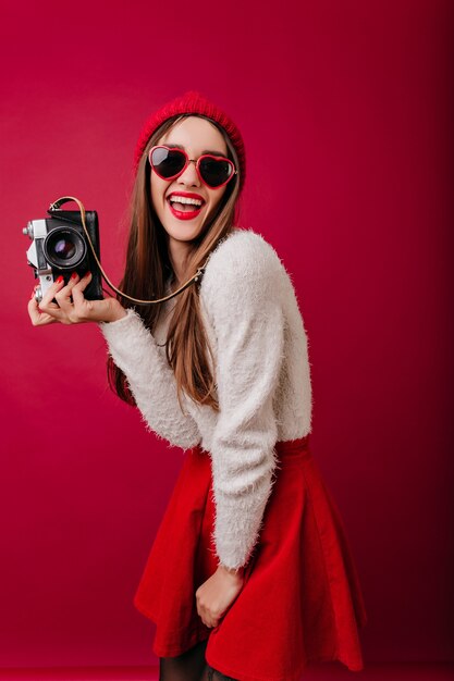 Garota rindo e incrível usando chapéu vermelho dançando