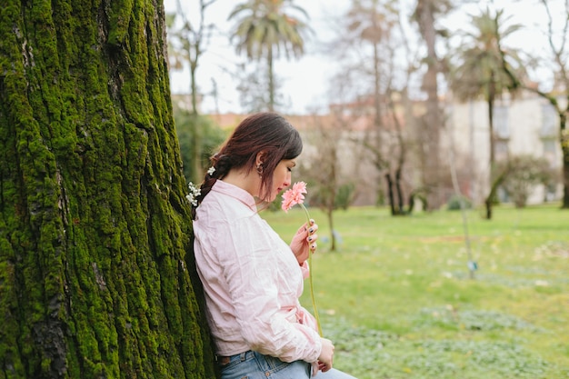 Garota romântica cheirando a flor no jardim