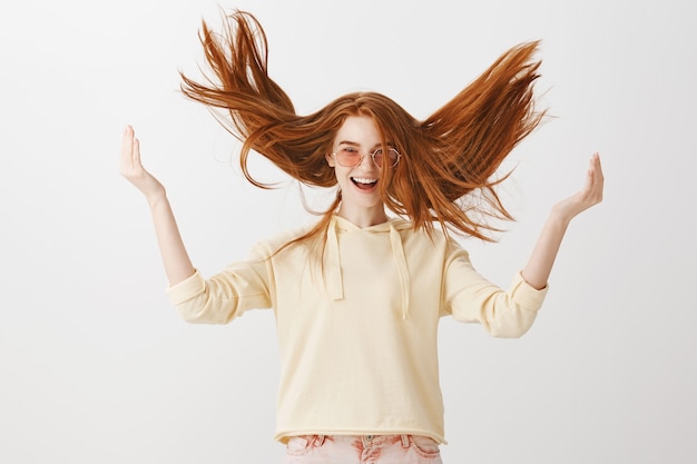 Foto grátis garota ruiva linda e despreocupada jogando o cabelo para o alto