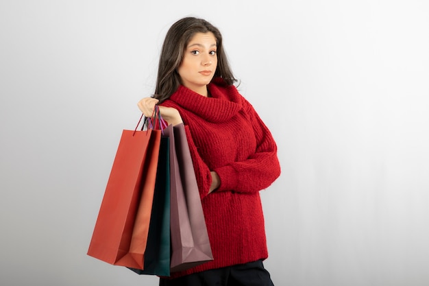 garota séria segurar sacolas de compras.