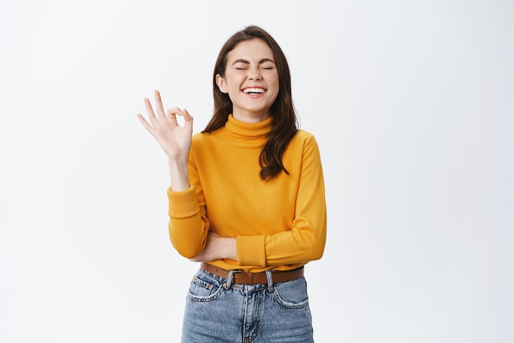 Foto grátis garota sincera feliz rindo e mostrando sinal de ok para elogiar uma boa piada se divertindo concordando ou gostando de algo satisfeito contra o fundo branco