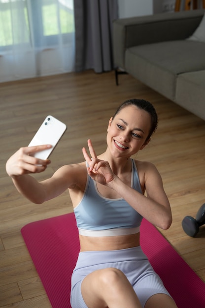 Foto grátis garota sorridente de alto ângulo tomando selfie