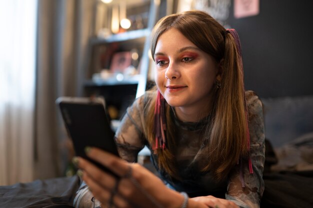 Garota sorridente de tiro médio segurando smartphone