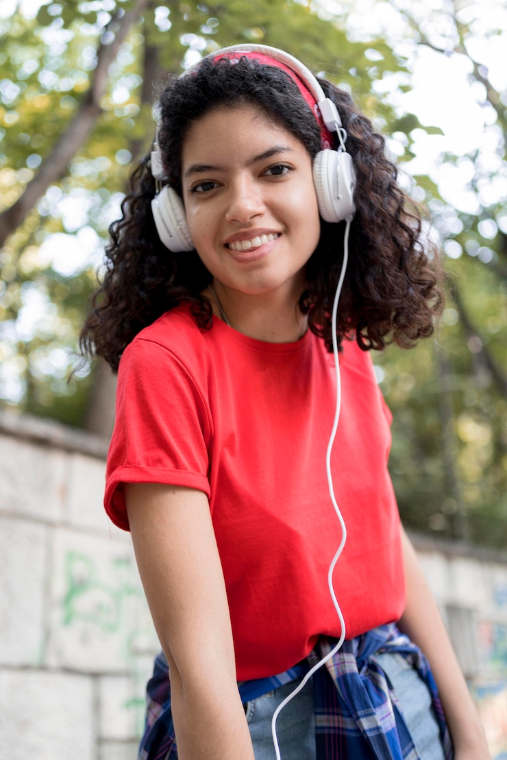 Foto grátis garota sorridente de tiro médio usando fones de ouvido