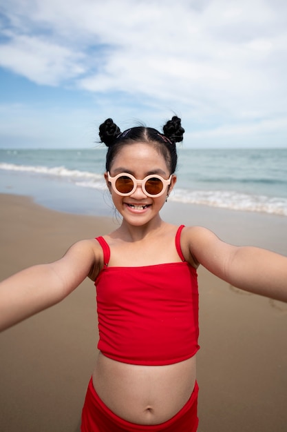 Foto grátis garota sorridente de vista frontal na praia