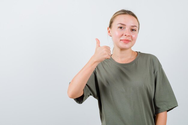 Garota sorridente mostrando um bom sinal de mão no fundo branco