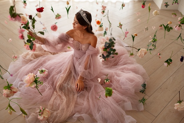 Foto grátis garota sorridente posando com flores de alto ângulo