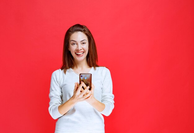 Garota tirando uma selfie ou fazendo uma chamada de vídeo.