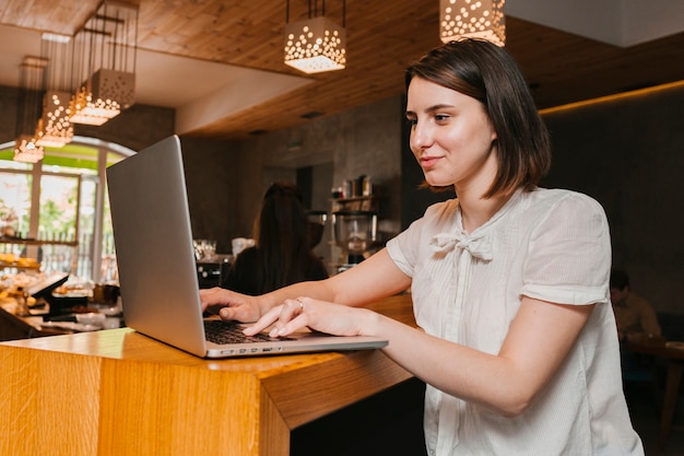 Garota trabalhando no laptop no café