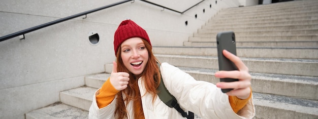 Foto grátis garota urbana tira selfie nas escadas da rua e usa aplicativo de smartphone para tirar fotos de si mesma