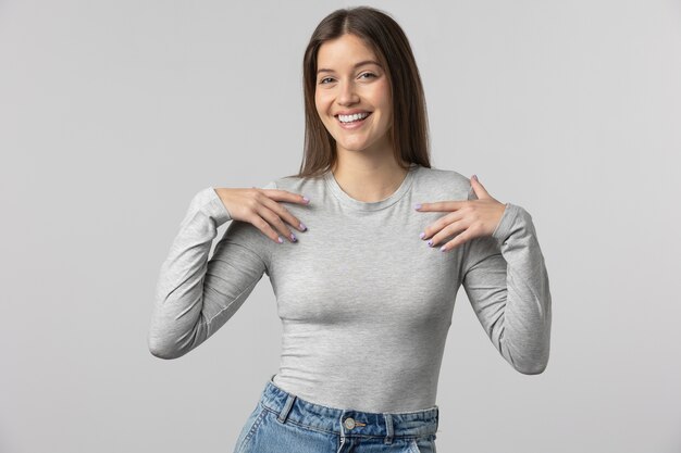 Garota vestindo camiseta cinza posando no estúdio