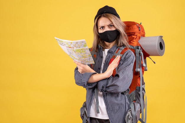 Garota viajante com máscara preta e mochila segurando mapa