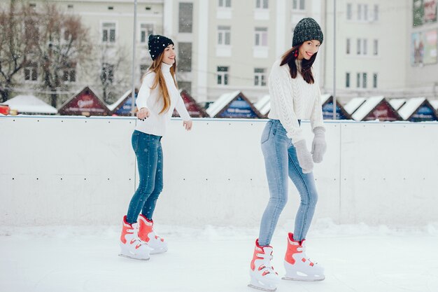 Garotas bonitas e bonitas com um suéter branco em uma cidade de inverno