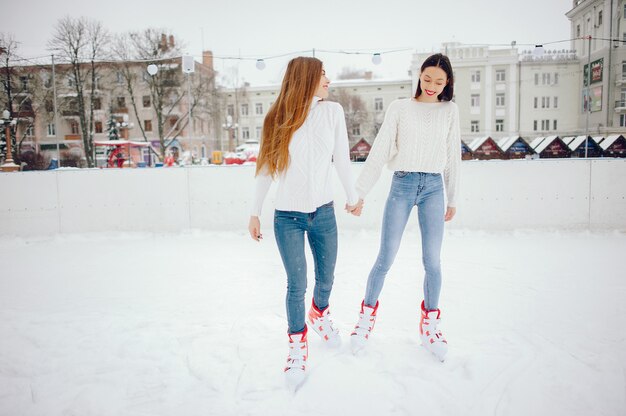 Garotas bonitas e bonitas com um suéter branco em uma cidade de inverno