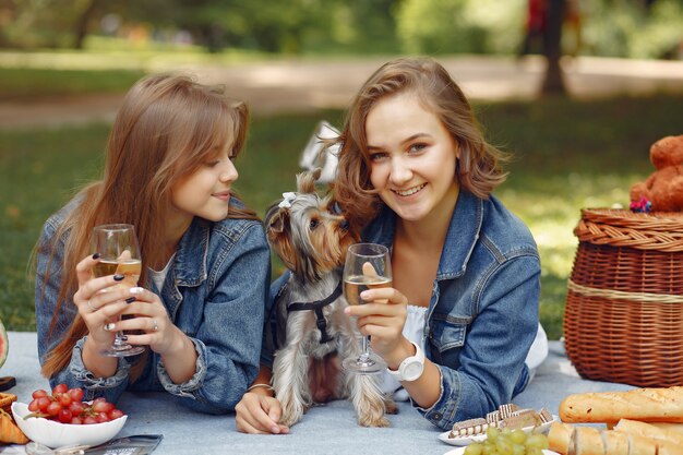 garotas bonitas em um parque brincando com cachorro