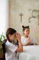 Foto grátis garotas de vista lateral rezando juntas
