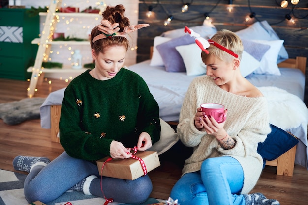 Garotas felizes preparando um presente de natal