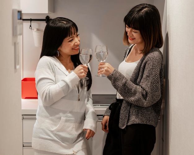 Garotas lindas asiáticas curtindo vinho juntas