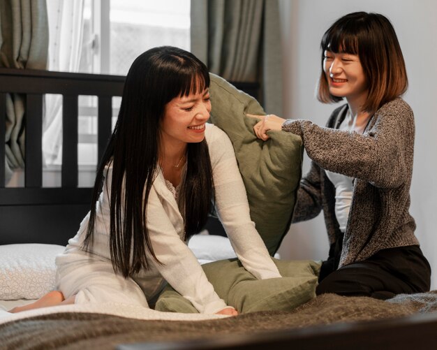Garotas lindas asiáticas lutando com travesseiro