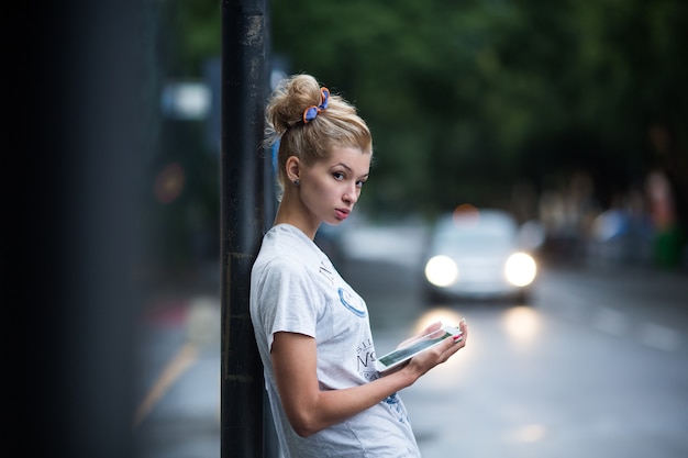 Garotas lindas com tablet em um ponto de ônibus