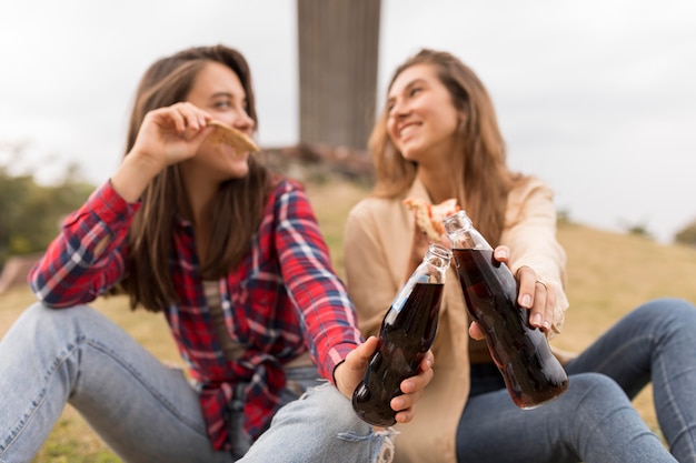 Foto grátis garotas sorridentes com pizza e refrigerante