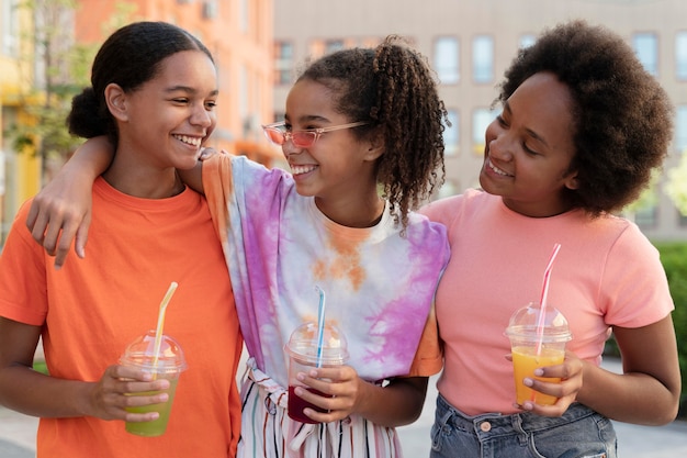 Foto grátis garotas sorridentes de tiro médio segurando bebidas