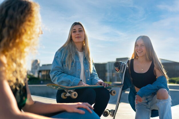 Garotas sorridentes de vista frontal no parque de skate