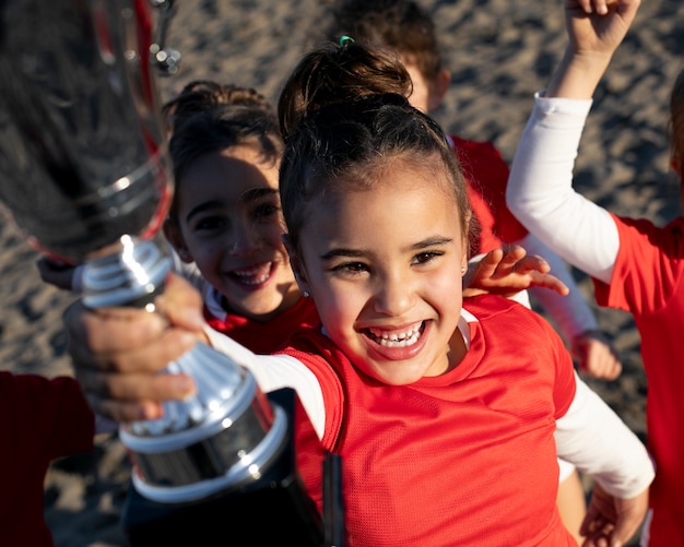 Foto grátis garotas sorridentes segurando troféu na praia