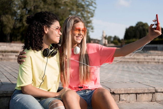 Foto grátis garotas tirando selfies ao ar livre