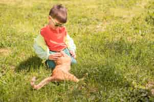 Foto grátis garotinho brincando com gato